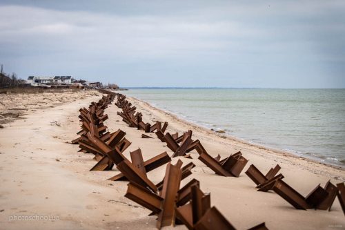«Український Дюнкерк». Панорамний вигляд на курортні елінги, які стоять на березі Азовського моря. Узбережжя суцільно заміноване та укріплене протидесантним загородженням на випадок висадки десанту противника з моря. Місто на горизонті, то вже Новоазовськ
