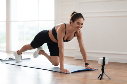 Smiling,Lady,Training,At,Home,In,Front,Of,Cellphone,On