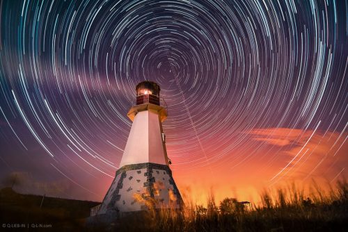 lighthouse with night sky at background stars trails